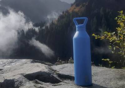 a classy water bottle in a dramatic mountain scene